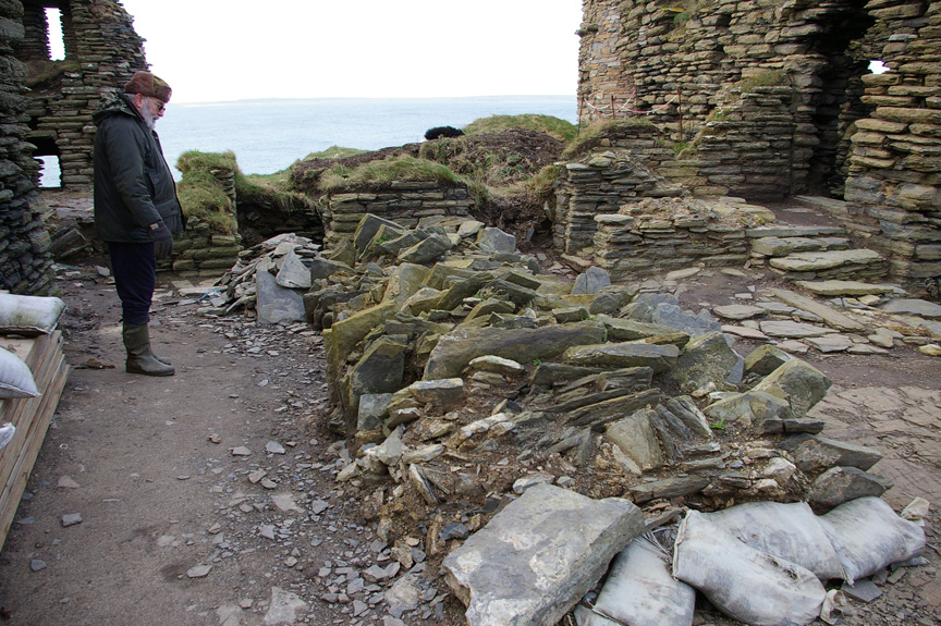 Ian Sinclair looks over rubble from a collapsed chimney at Castle Sinclair